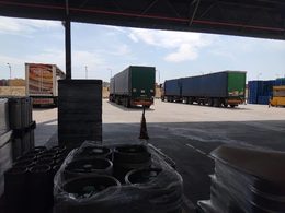 Curtain-side trailers being offloaded during beverage packaging supply